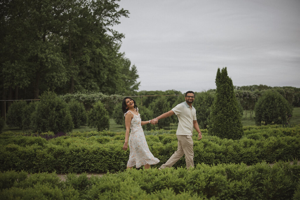 Couple walking through the formal gardens at Allerton Park during an engagement photo session near Champaign-Urbana.