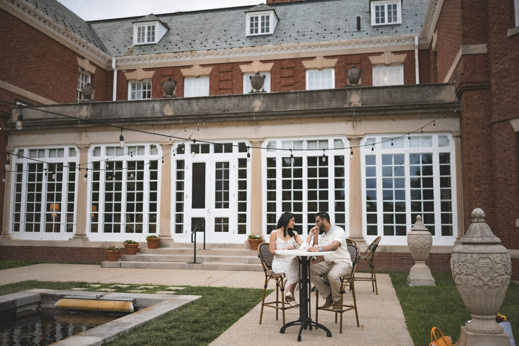 Couple enjoying a romantic engagement session in front of the historic mansion at Allerton Park in Monticello, Illinois.