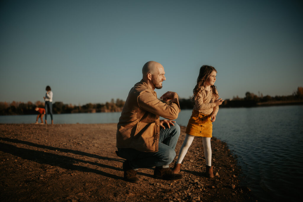 : "Family enjoying time by the lake at River Bend Forest Preserve in Mahomet, IL, with a golden sunset, captured by Light By Zoey Photography, Champaign, IL."