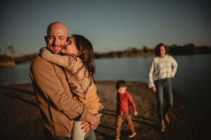 : "Family enjoying time by the lake at River Bend Forest Preserve in Mahomet, IL, with a golden sunset, captured by Light By Zoey Photography, Champaign, IL."