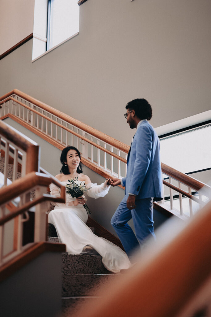 Bride and groom sharing a moment on the staircase during their Champaign County Courthouse wedding in Urbana Illinois