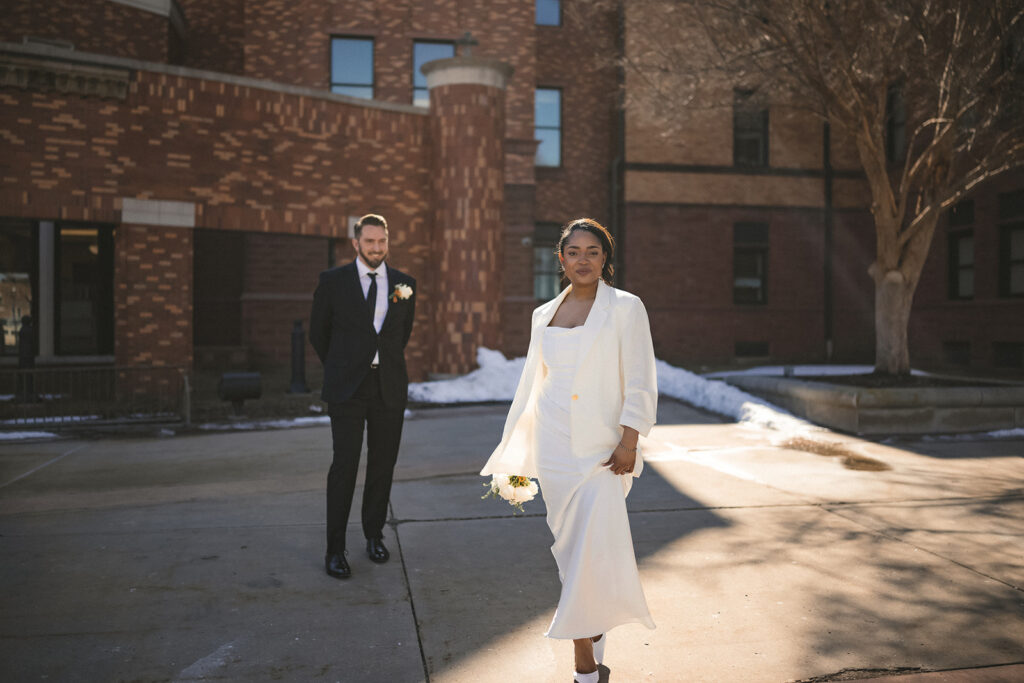Newly married couple taking portraits outside the Champaign County Courthouse in Urbana, Illinois.