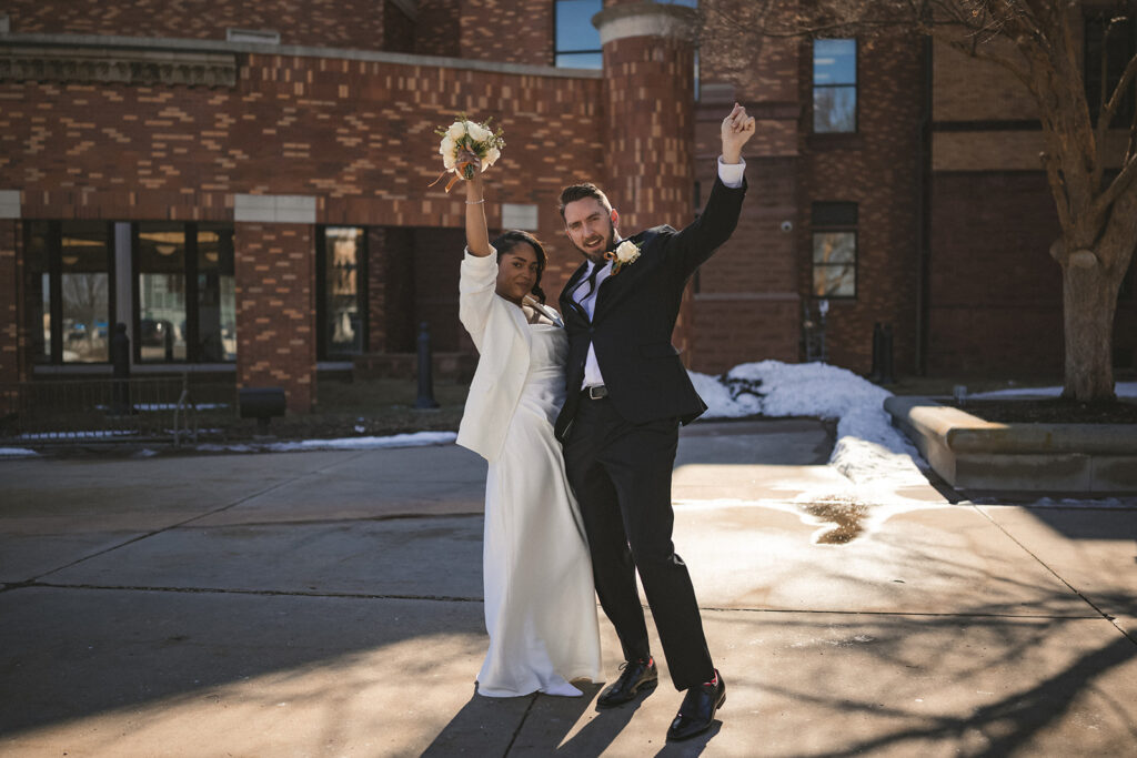 Bride and groom celebrating outside the Champaign County Courthouse after their intimate courthouse wedding in Illinois.