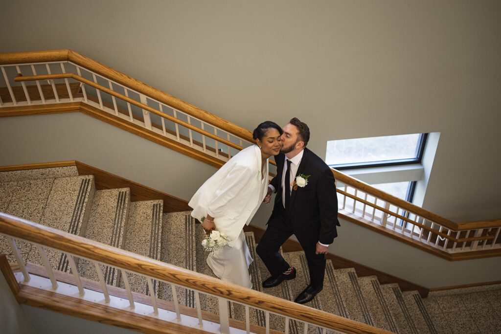 Bride and groom sharing a kiss on the courthouse staircase during their Champaign County courthouse wedding in Urbana, Illinois.
