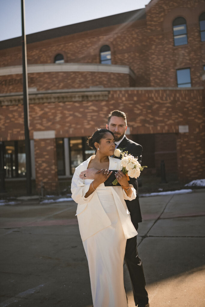 Newly married couple embracing outside the Champaign County Courthouse in Urbana, Illinois.