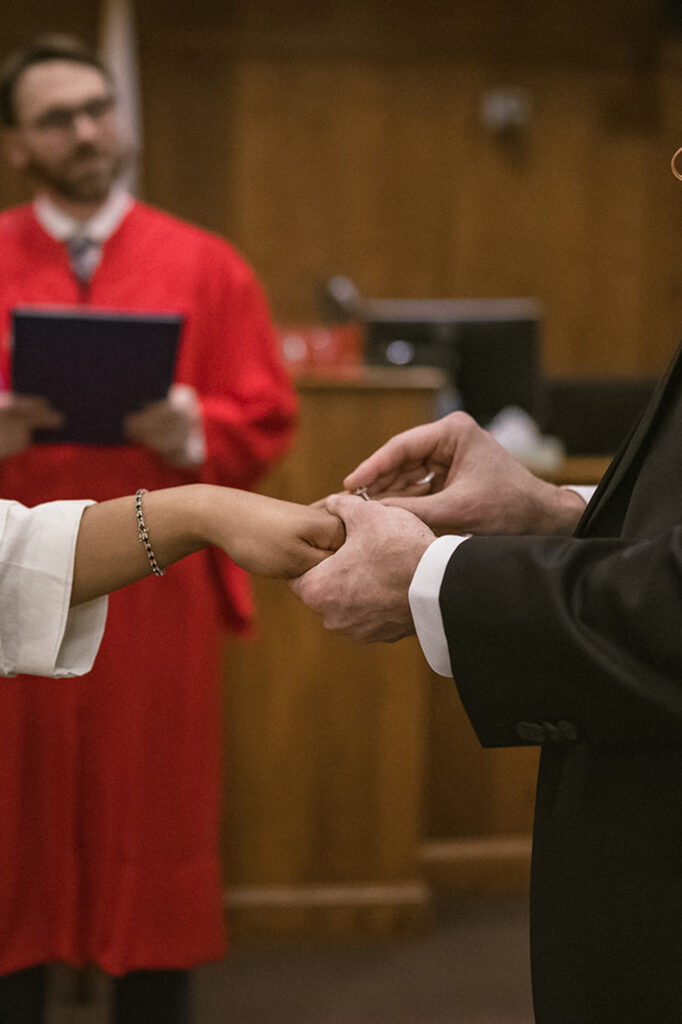 Couple exchanging wedding rings during a courthouse wedding ceremony in Champaign Illinois.