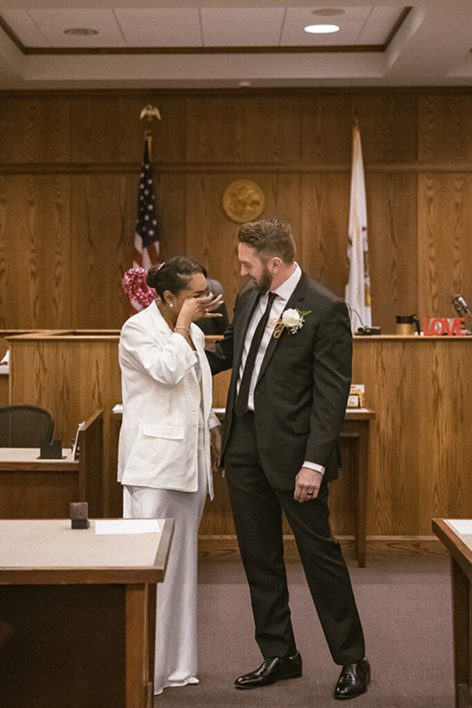 Bride wiping away tears during an emotional courthouse wedding ceremony in Champaign Illinois.