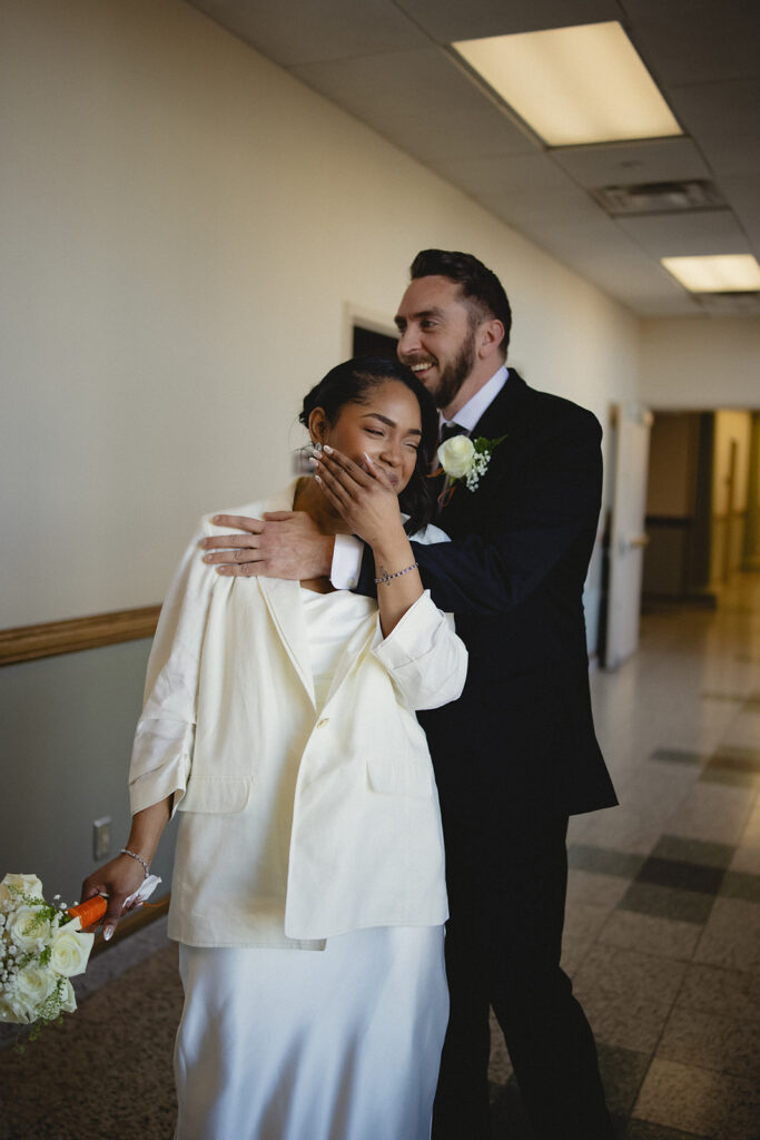 Bride laughing during an emotional moment with her husband after their Champaign County courthouse wedding in Urbana, Illinois.