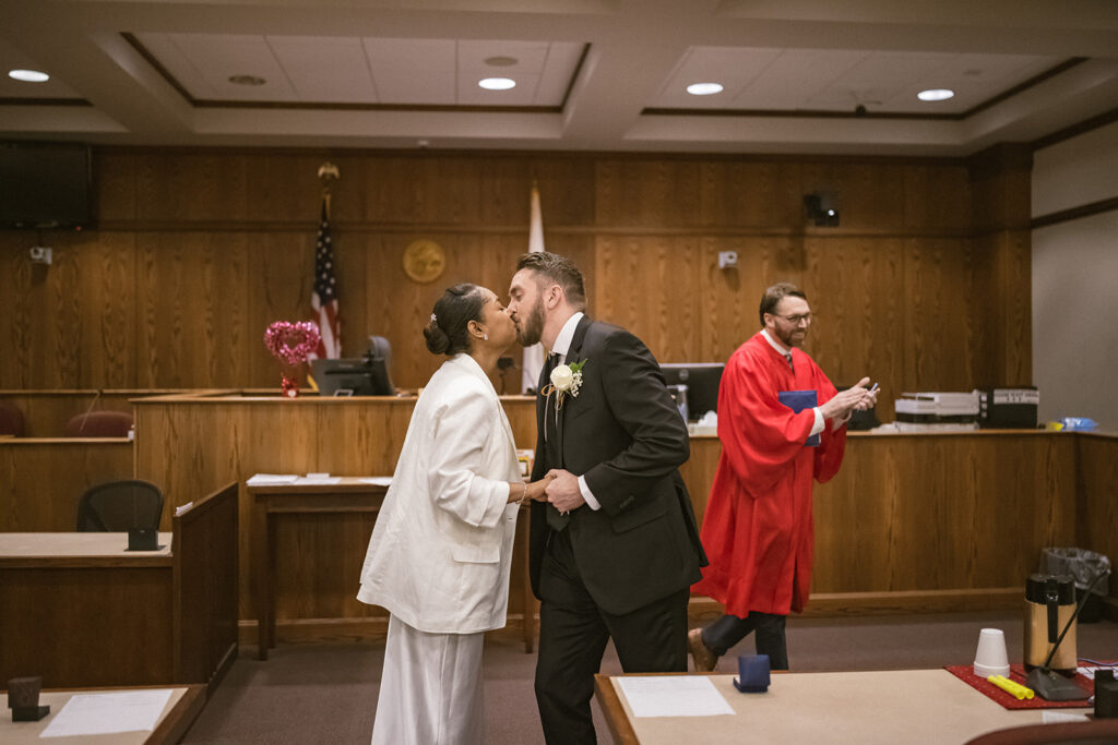 Newly married couple sharing their first kiss during a courthouse wedding ceremony in Urbana, Illinois.